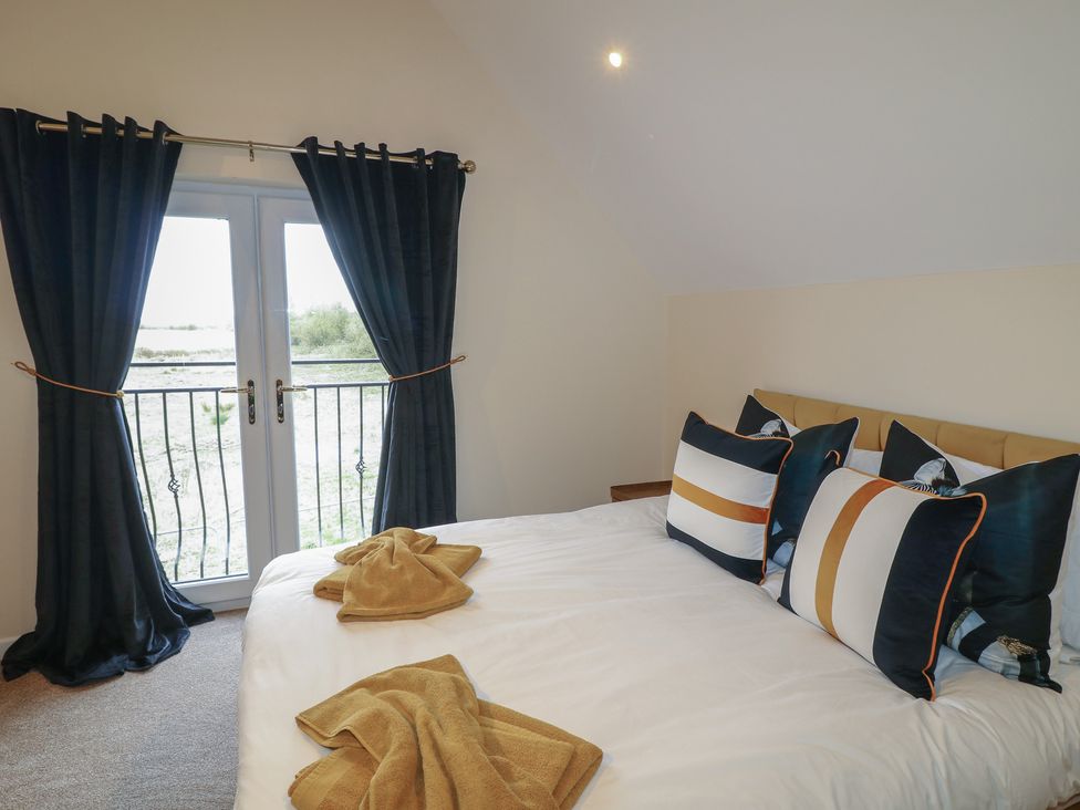 A bedroom with a bed and pillows at Poker Lodge in Brigg