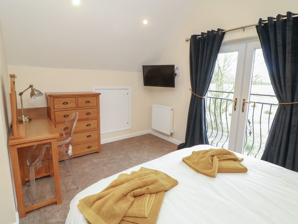 A bedroom with a bed and desk at Poker Lodge in Brigg