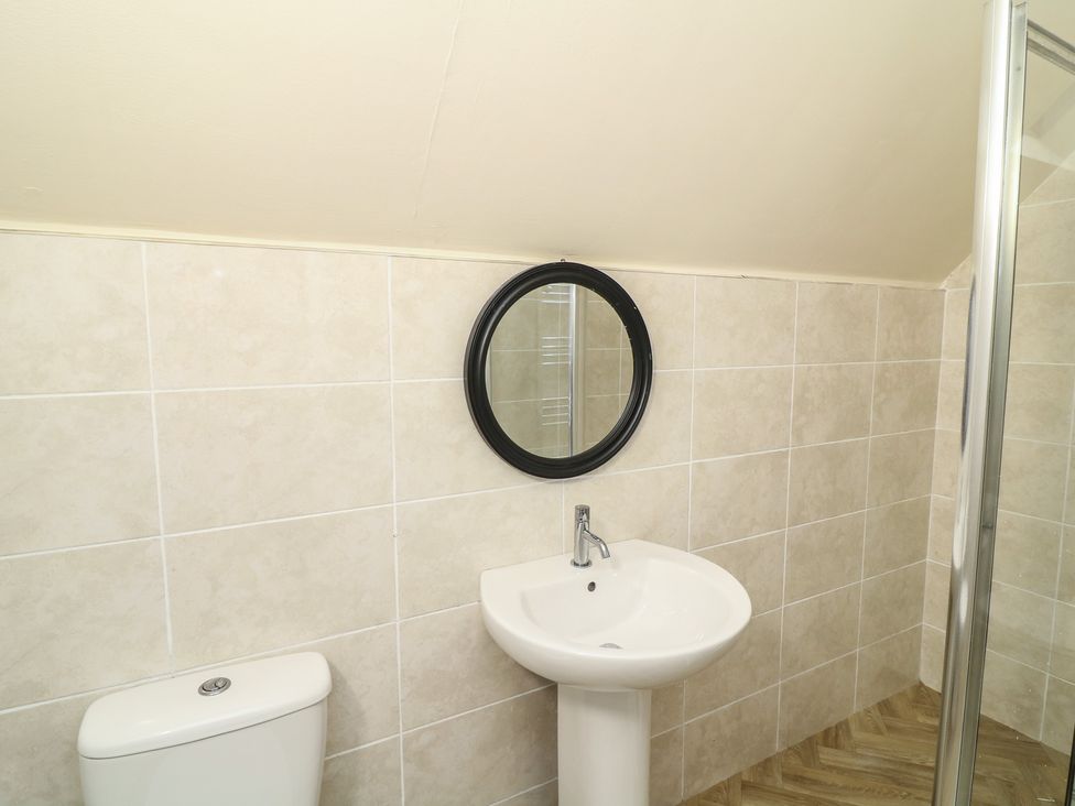 A bathroom with a toilet and sink in Poker Lodge Brigg