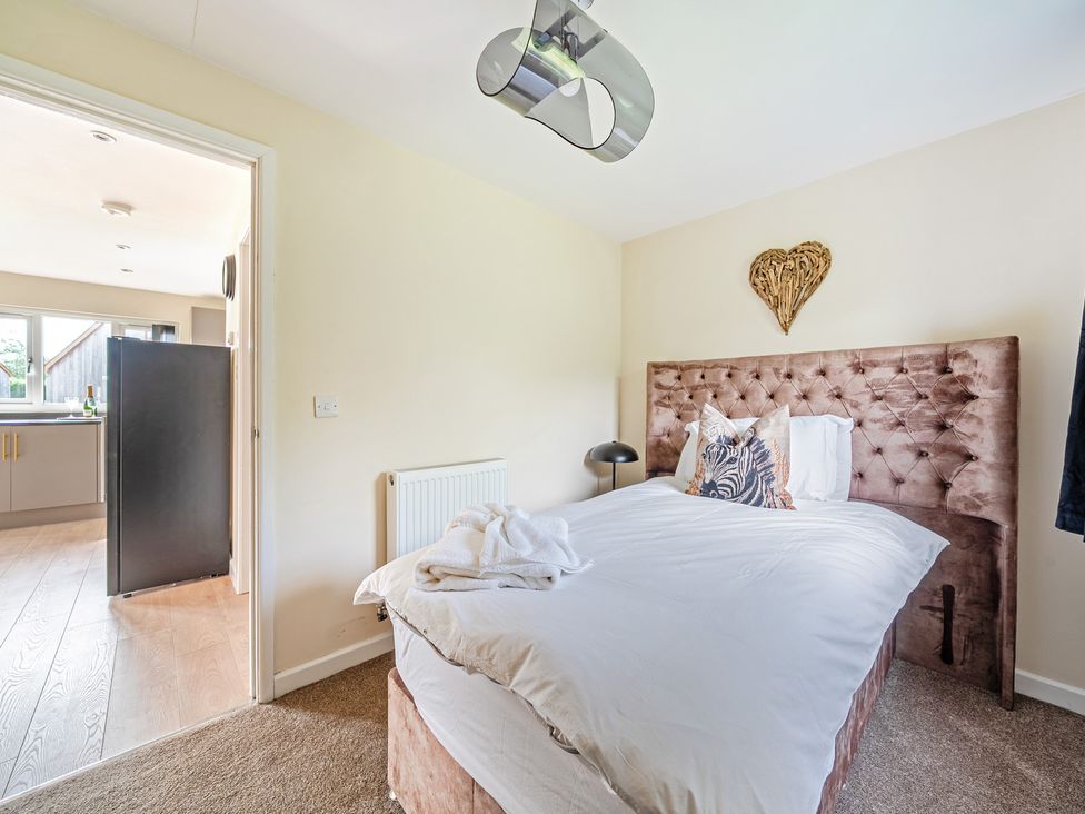 A bedroom with a bed and a doorway leading to another room at Poker Lodge Near Brigg