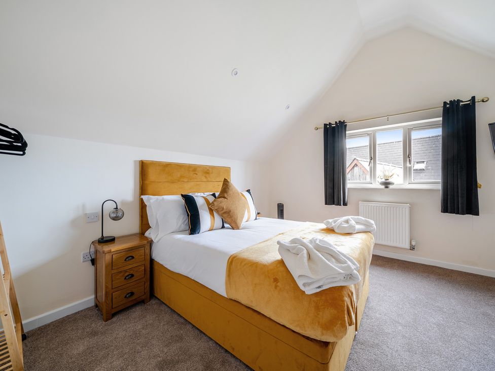 A bedroom with a bed and window at Poker Lodge near Brigg