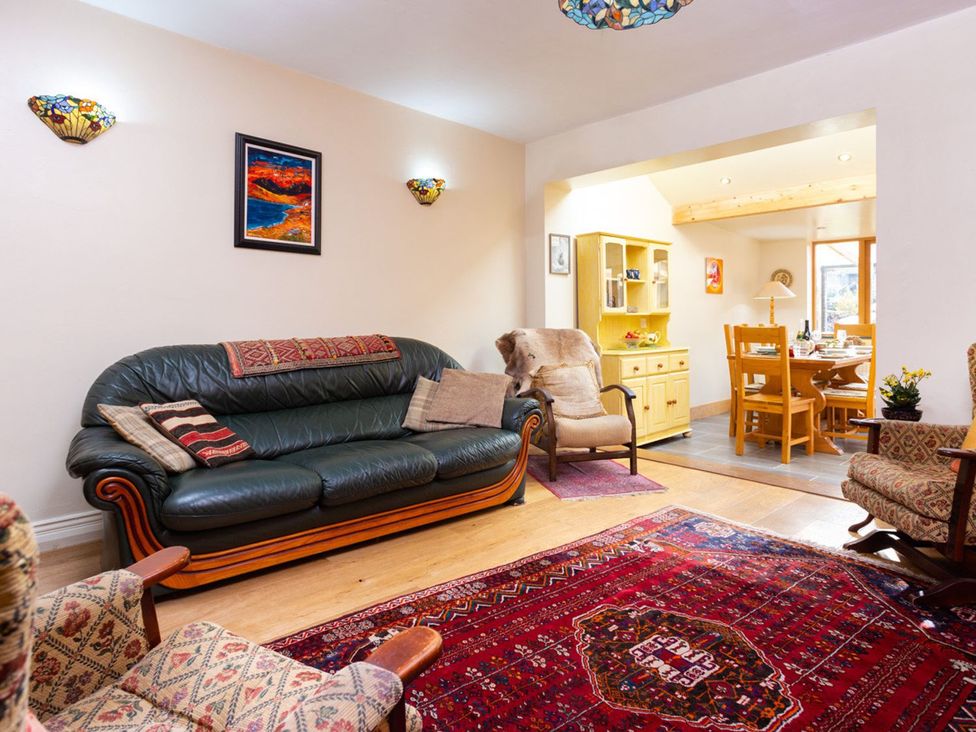 A living room with a sofa and dining area at Oakdene in Keswick