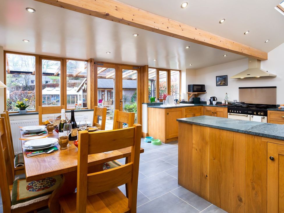 A kitchen with wooden furniture and appliances at Oakdene in Keswick
