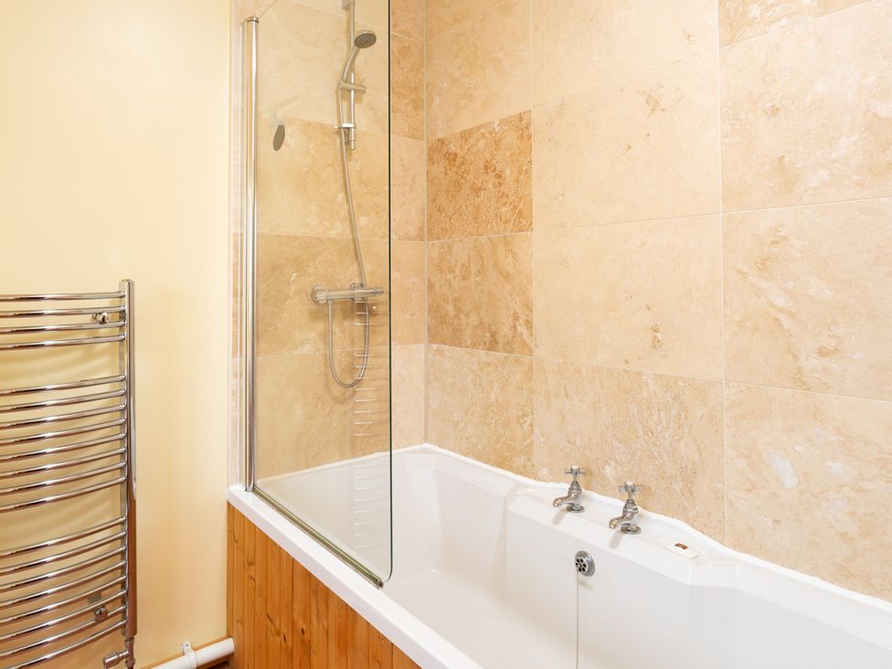 A bathroom with a bathtub and shower at Oakdene in Keswick