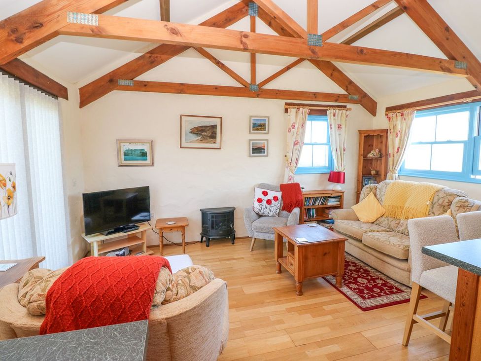 A living room with a tv and sofa at Casa Mia Goodwick