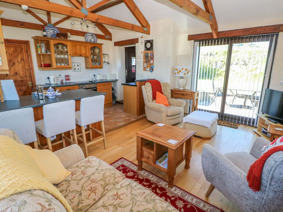 A living room with a kitchen area and seating at Casa Mia in Goodwick
