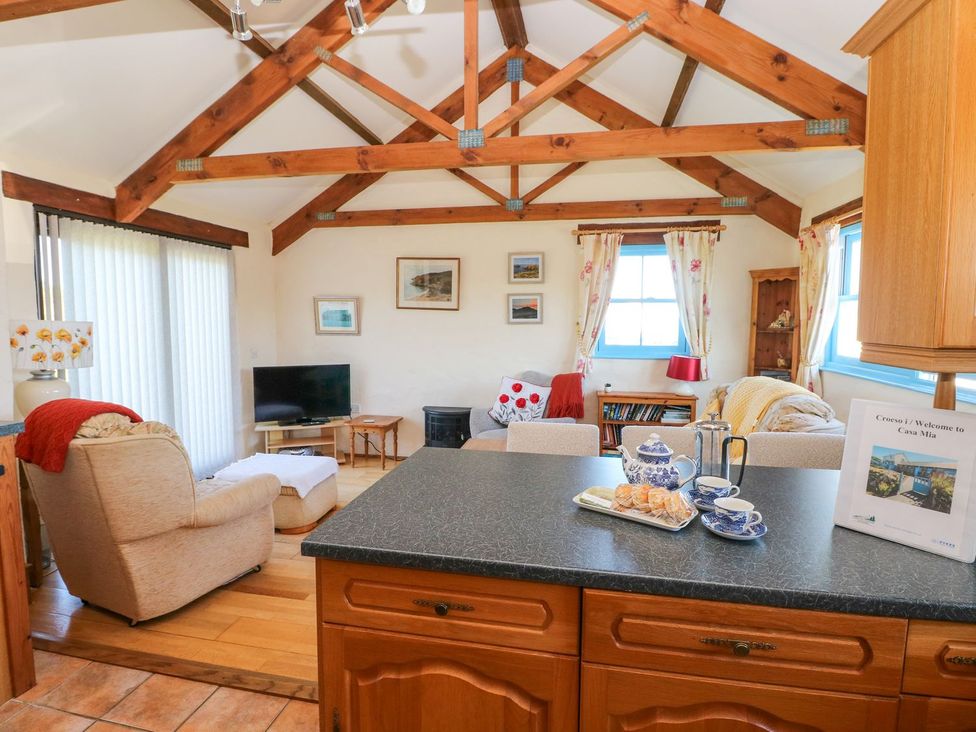 A living room with a television and furniture at Casa Mia in Goodwick