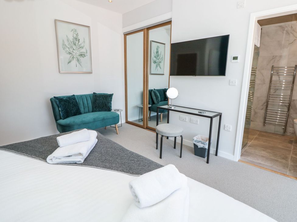 A bedroom with a bed, couch and mirror in Galvayne Dartmouth