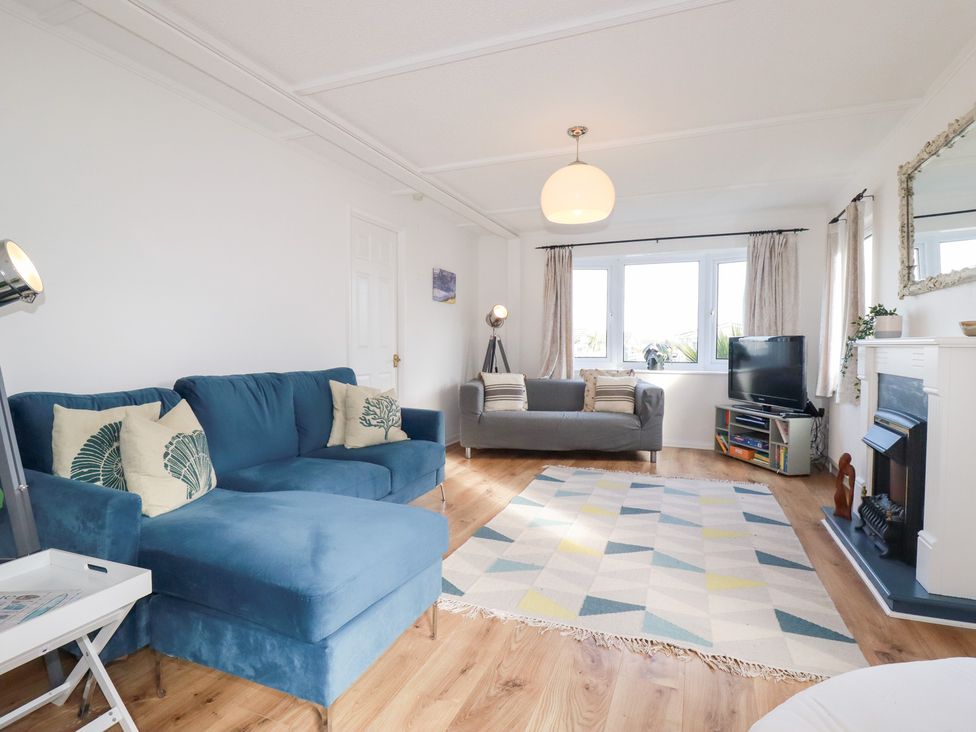 A living room with a blue sofa and a television at Ms Merryn 37 St. Cadocs