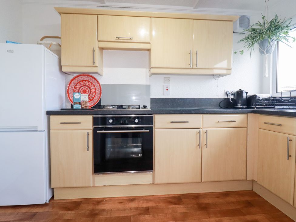 A kitchen with a fridge, oven, and kettle at Ms Merryn 37 St. Cadocs