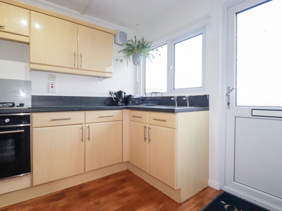 A kitchen with cabinets and sink at Ms Merryn 37 St. Cadocs