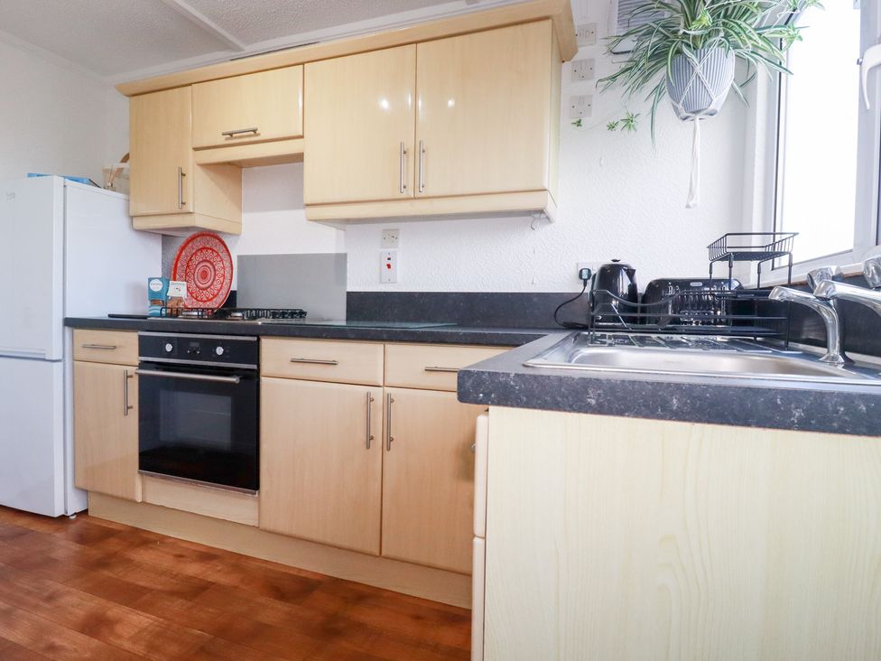 A kitchen with cabinets and appliances at Ms Merryn 37 St. Cadocs