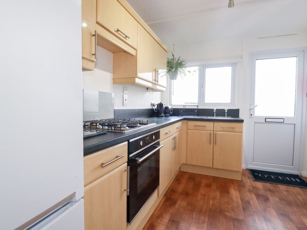 A kitchen with appliances and cabinetry at Ms Merryn 37 St. Cadocs