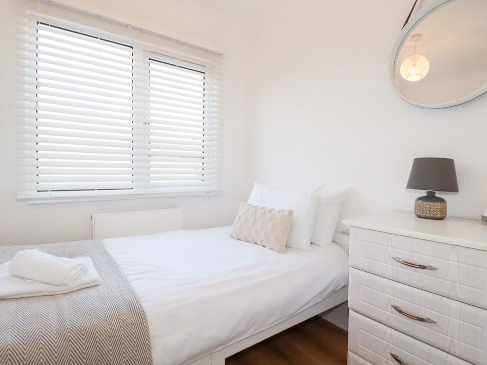 A bedroom with a bed and dresser at Ms Merryn 37 St. Cadocs