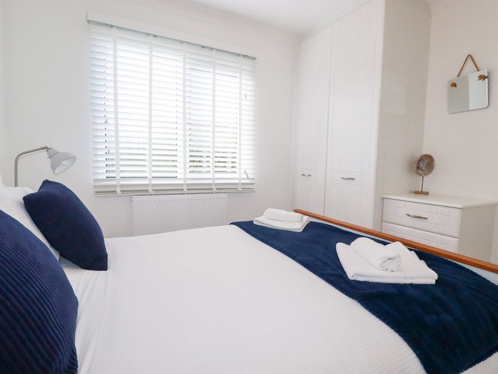 A bedroom with a bed and wardrobe at Ms Merryn 37 St. Cadocs