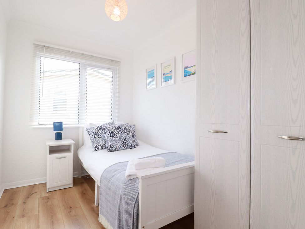 A bedroom with a bed, wardrobe and nightstand at Ms Merryn 37 St. Cadocs