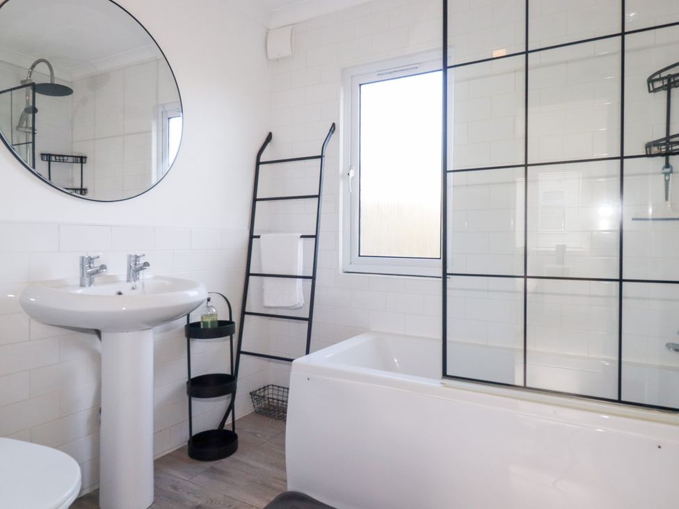 A bathroom with a sink, bathtub, shower, and mirror at Ms Merryn 37 St. Cadocs