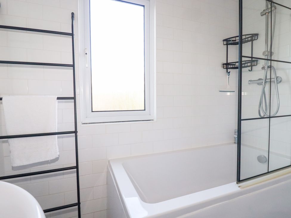 A bathroom with a bathtub, towel rack, and shower at Ms Merryn 37 St. Cadocs