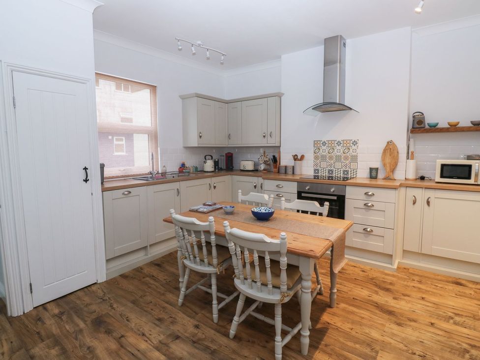 A kitchen with a table and chairs at The English School, Flat 2 in Dartmouth
