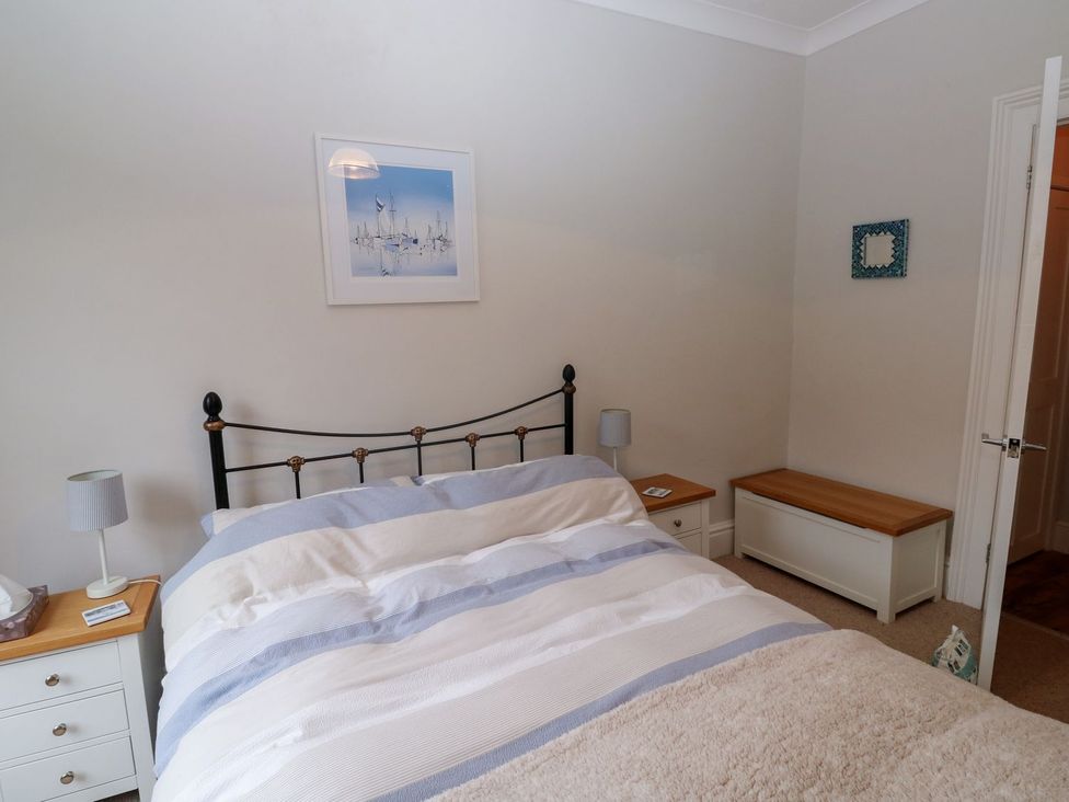 A bedroom with a bed and storage bench at The English School, Flat 2 in Dartmouth