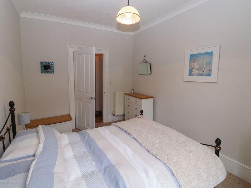 A bedroom with a bed and dresser at The English School, Flat 2 Dartmouth
