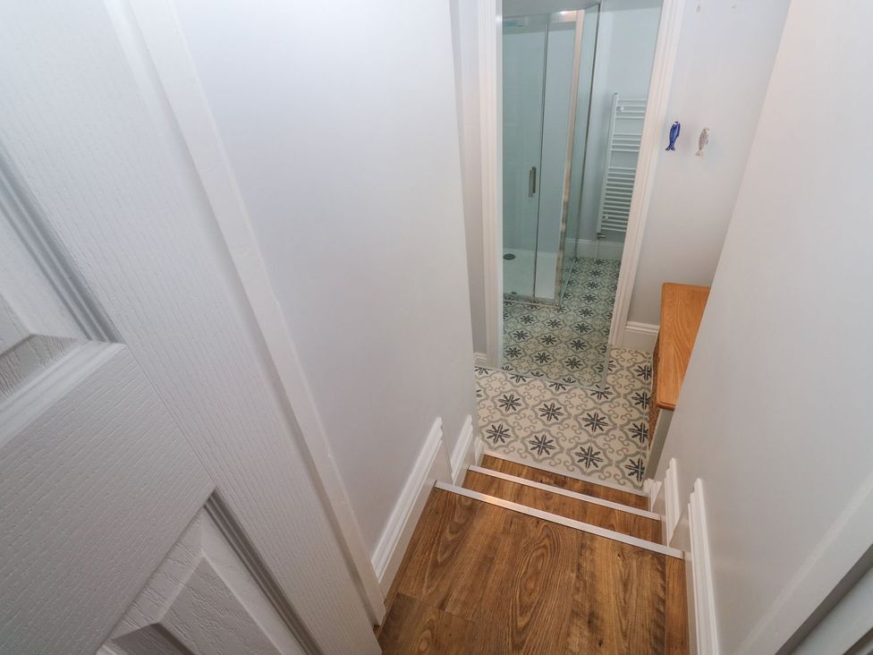 A view of stairs leading to a bathroom with a shower and a towel radiator at The English School, Flat 2 in Dartmouth