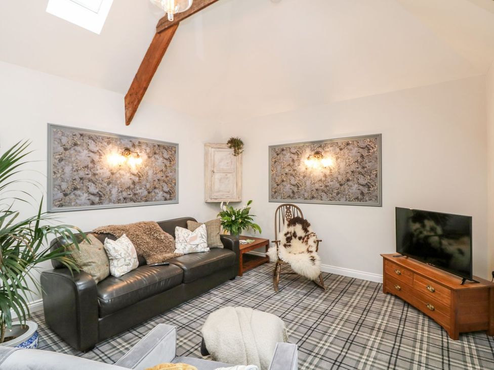 A living room with a sofa and television at The Old Byre in Falmouth