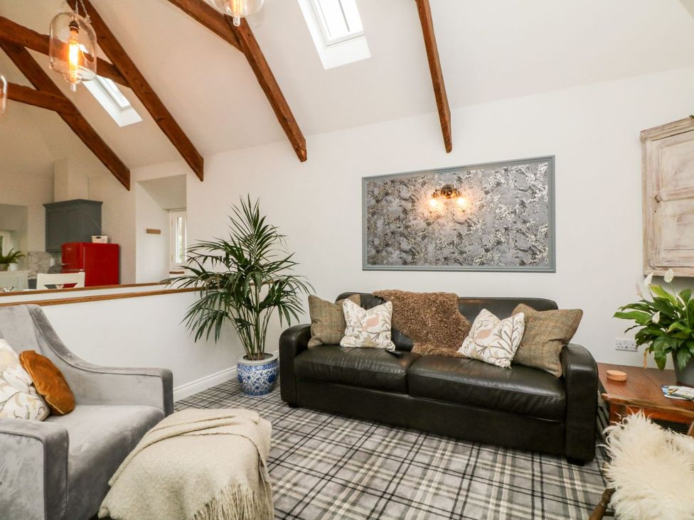 A living room with a sofa and plant at The Old Byre in Falmouth