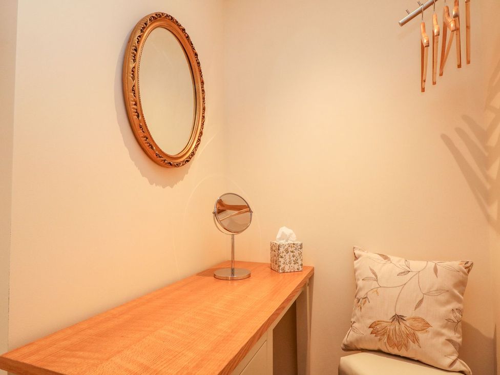 A bathroom with a vanity table and mirror at The Old Byre in Falmouth