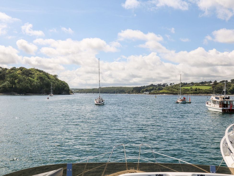 A view of boats on water with hills and clouds at The Old Byre in Falmouth