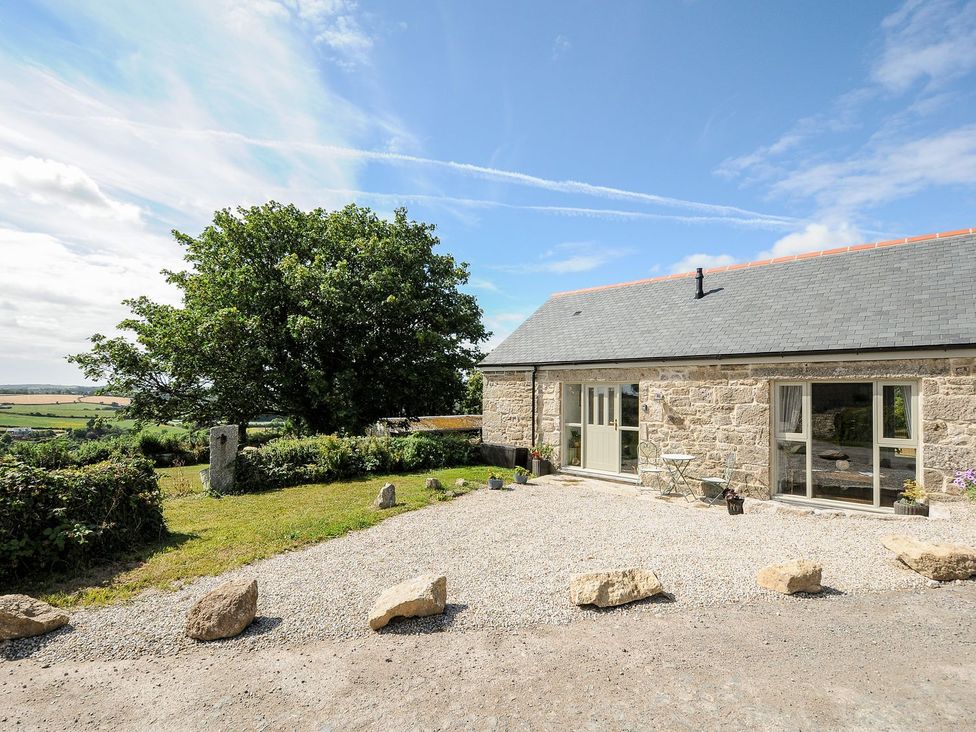 An outdoor view of a stone house with a gravel area at The Forge in Falmouth