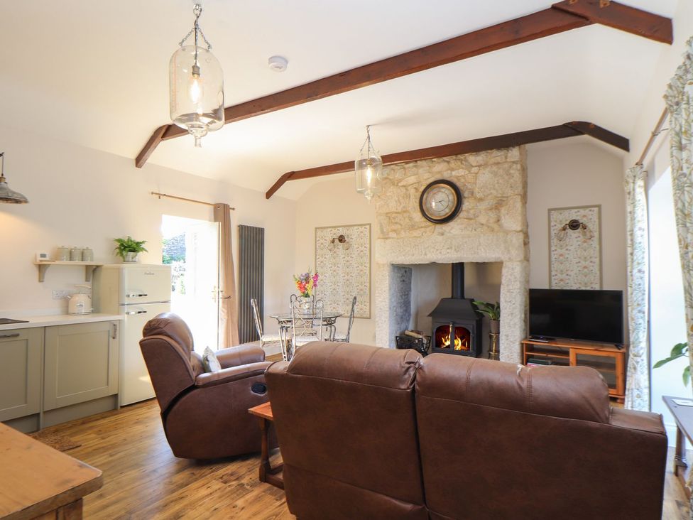 A living room with a sofa, fireplace, and television at The Forge in Falmouth