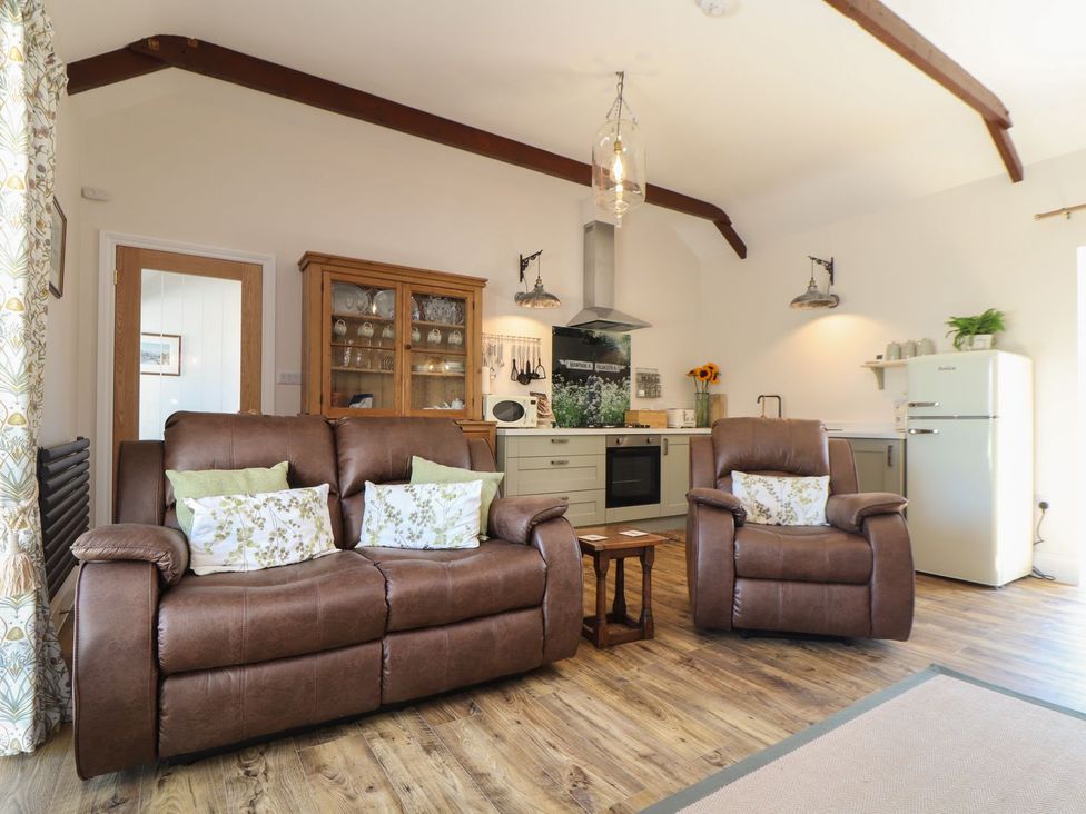 A living room with a sofa and armchairs at The Forge in Falmouth