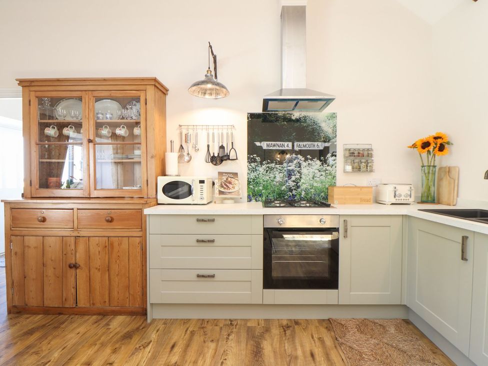 A kitchen with a cabinet, microwave, and oven at The Forge in Falmouth