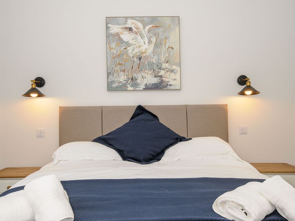 A bedroom with a bed and wall art at The Forge in Falmouth