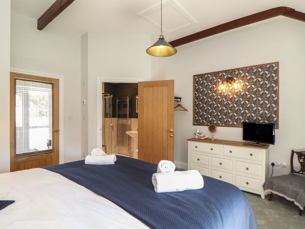 A bedroom with a bed and television at The Forge in Falmouth