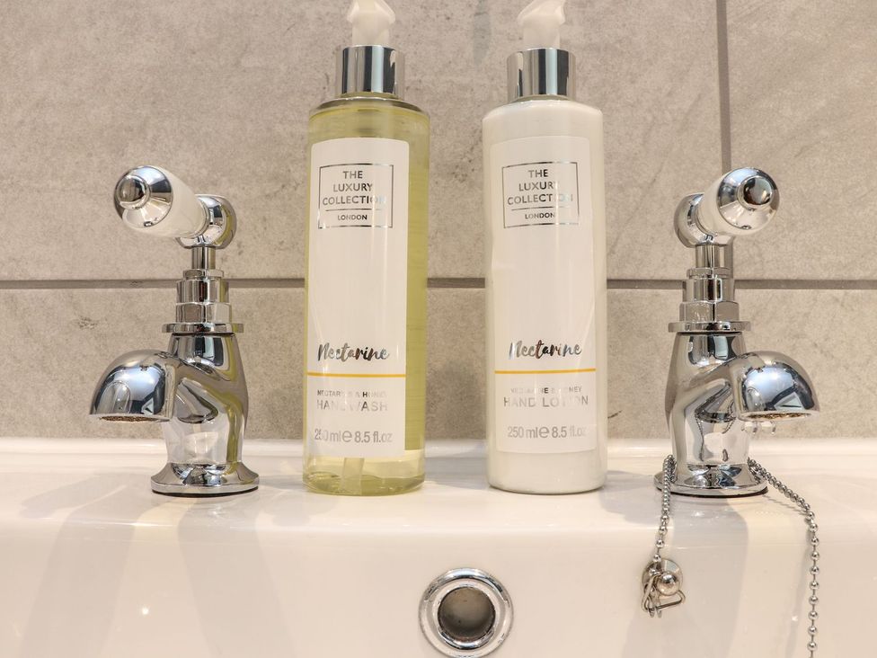 A sink with hand wash and hand lotion bottles at The Forge in Falmouth