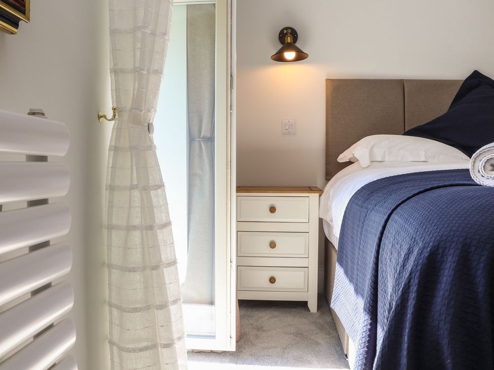 A bedroom with a bed and bedside table at The Forge in Falmouth