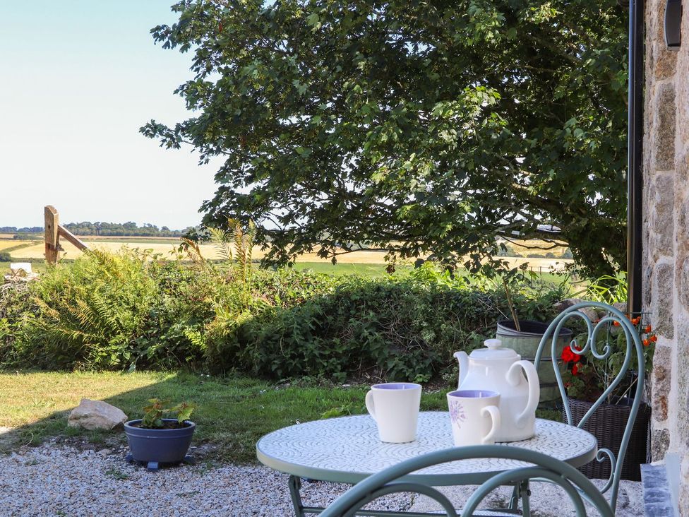 An outdoor seating area with a table and chairs at The Forge in Falmouth