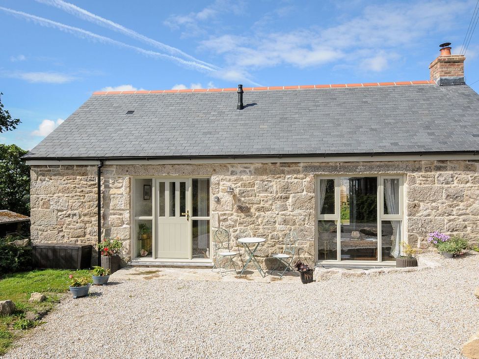 A house with a door and windows surrounded by gravel at The Forge in Falmouth