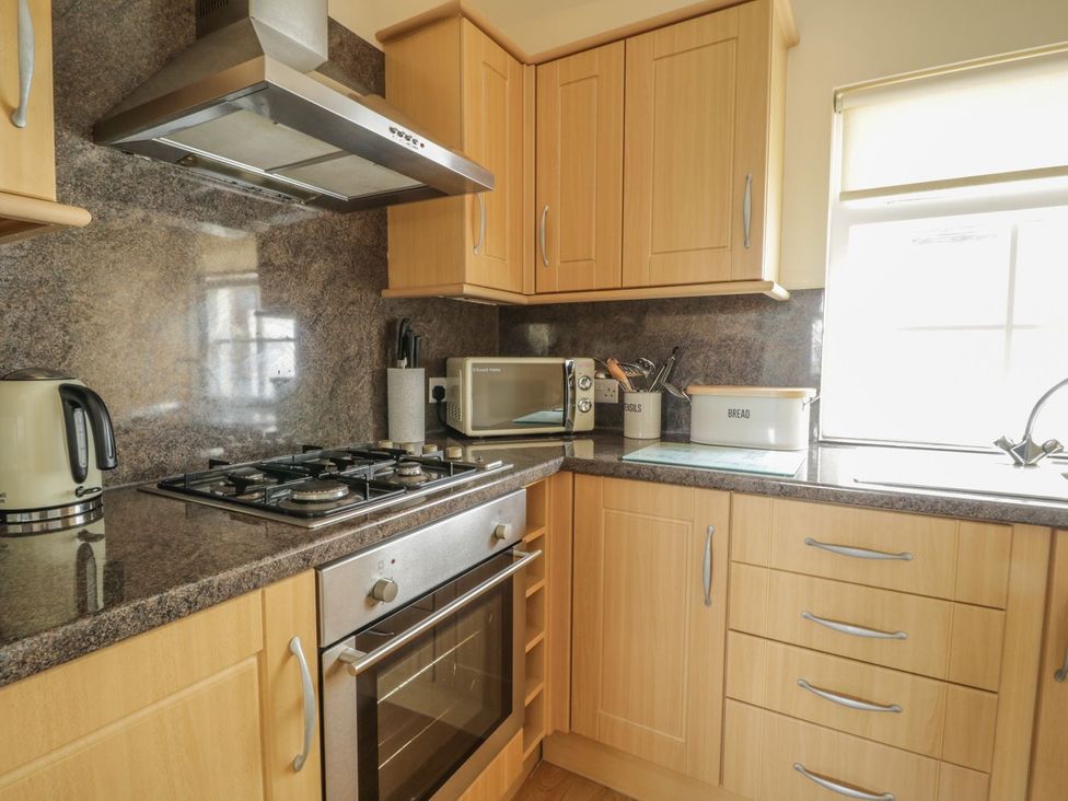 A kitchen with a stove and microwave at Cottage No 9 in Keswick