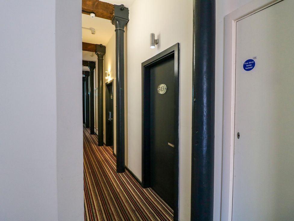 A hallway with doors and light fixtures at Apartments 212 in Nottingham