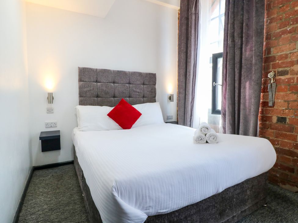 A bedroom with a bed, pillows, and towels at Apartments 212 Nottingham