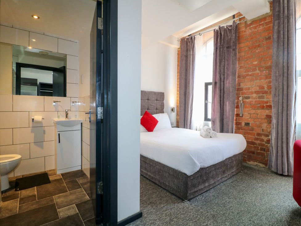 A bedroom with a bed and en-suite bathroom at Apartments 212 Nottingham