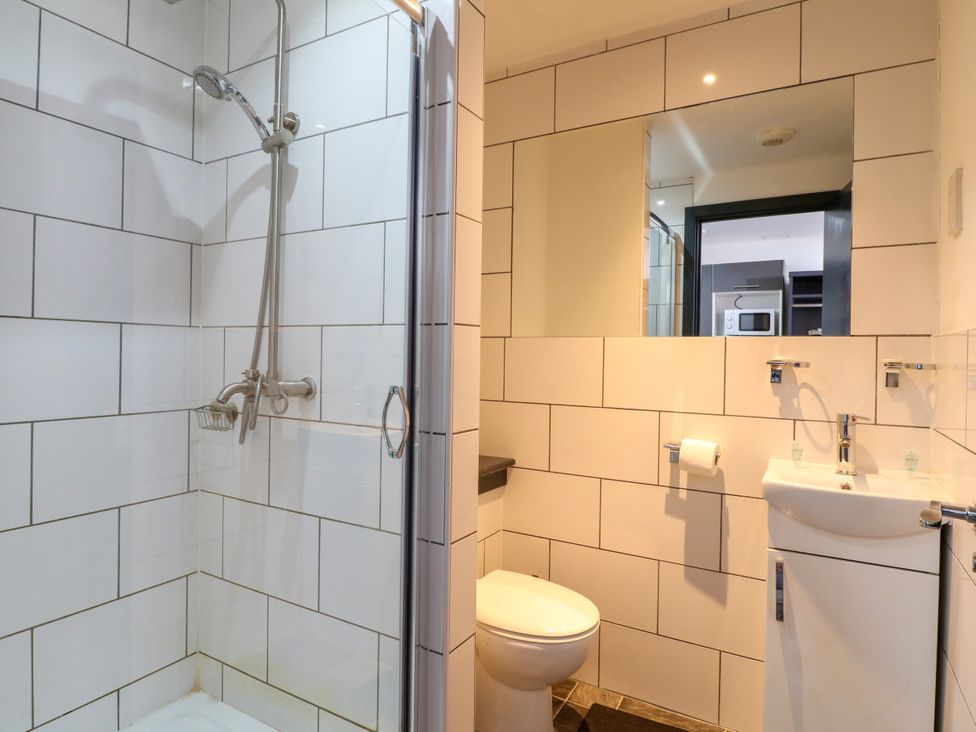 A bathroom with a shower, toilet, and sink at Apartments 212 Nottingham
