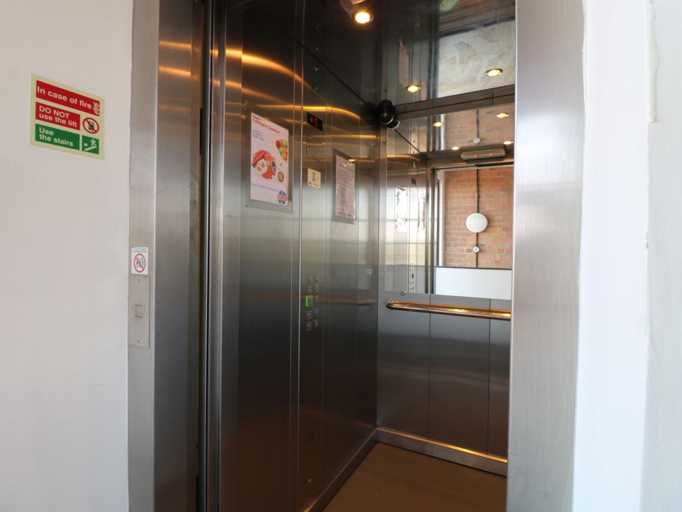 An elevator with buttons and a handrail at Apartments 212 Nottingham
