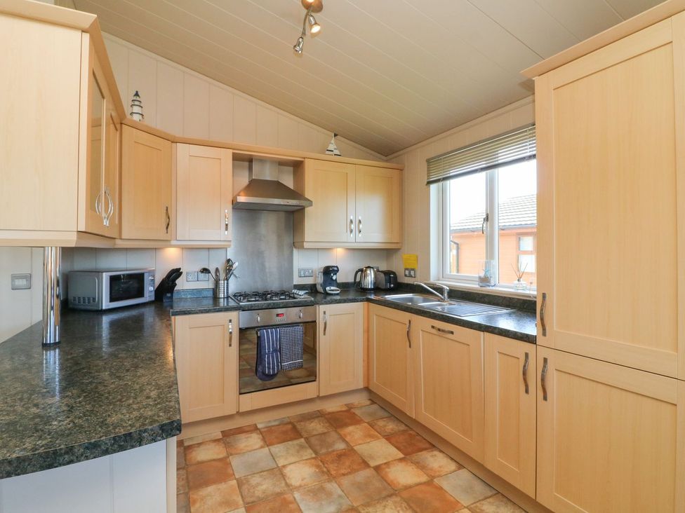 A kitchen with cabinets and appliances at 1 Ocean Terrace in Ilfracombe