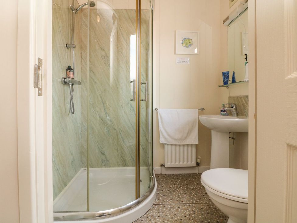 A bathroom with a shower toilet and sink at 1 Ocean Terrace Ilfracombe