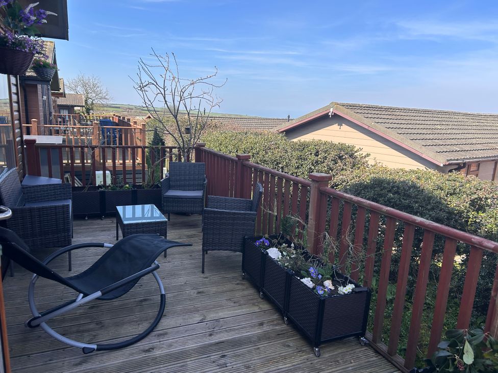 An outdoor seating area with chairs and table at 1 Ocean Terrace in Mullacott near Ilfracombe