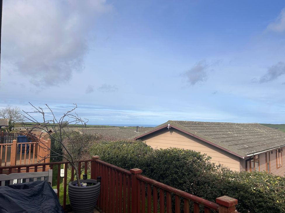 View from a deck with trees and houses in the foreground at 1 Ocean Terrace Mullacott near Ilfracombe